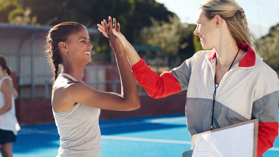 female basketball player giving her coach a high five