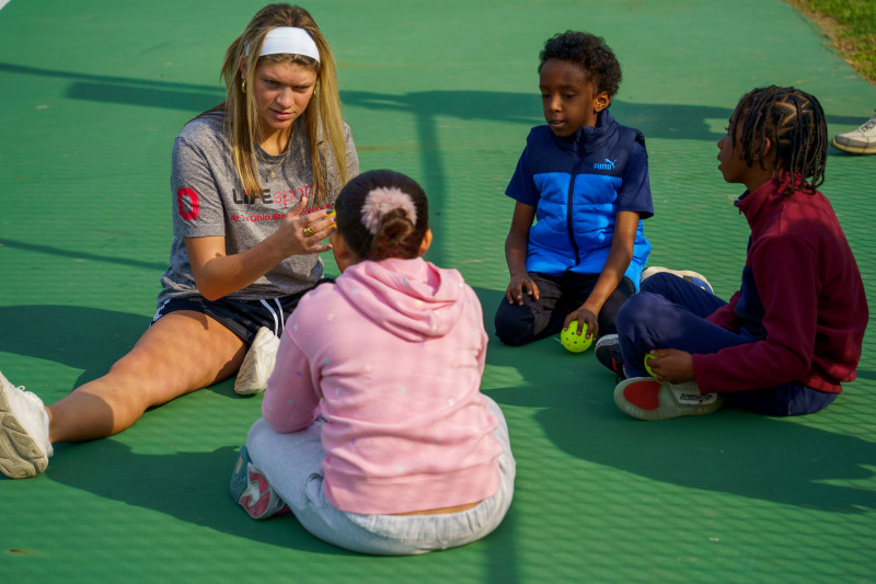 student sitting with children talking about sport